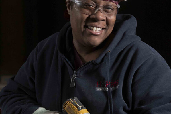 Black woman sheet metal worker holding Dewalt drill