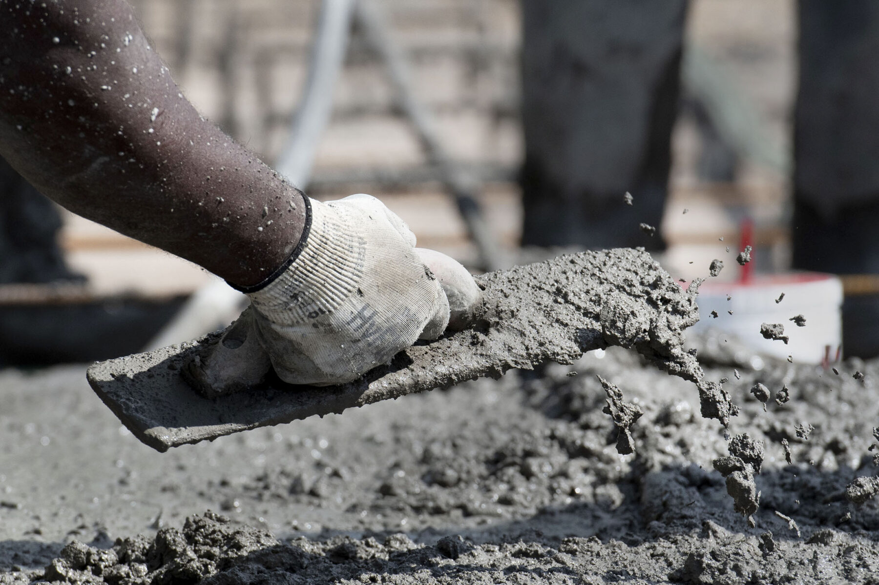 Cement mason scrapes cement pour