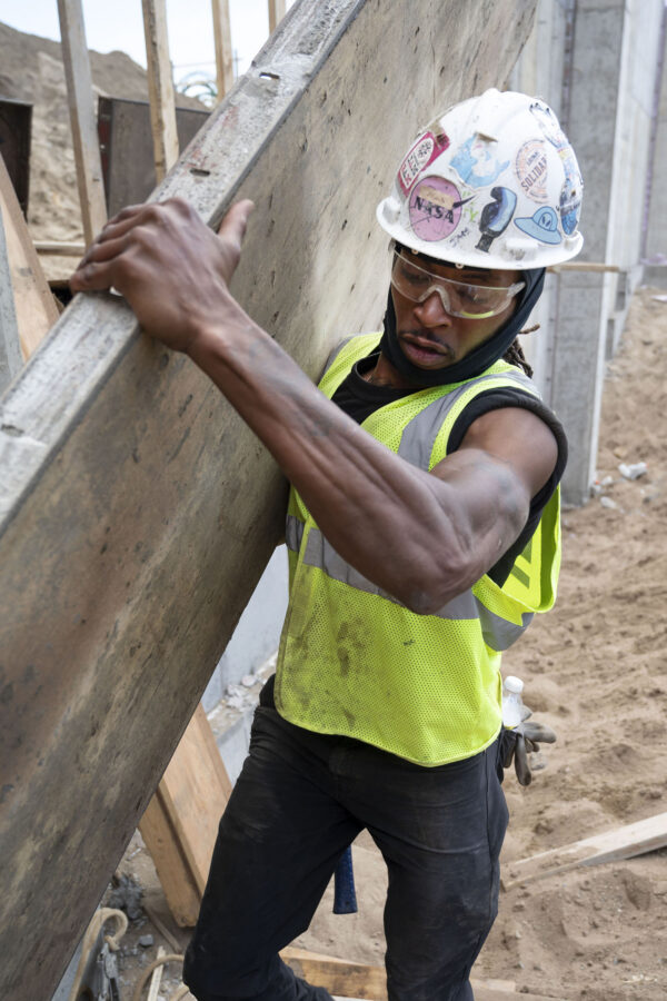 Laborers union worker carrying wood