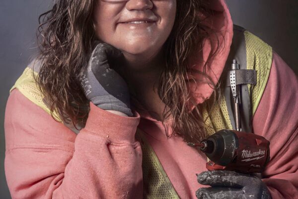 Female roofer holding Milwaukee drill